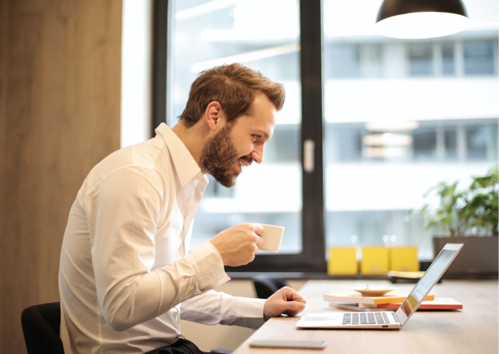 imprenditore fa consulenza online in ufficio mentre beve caffè
