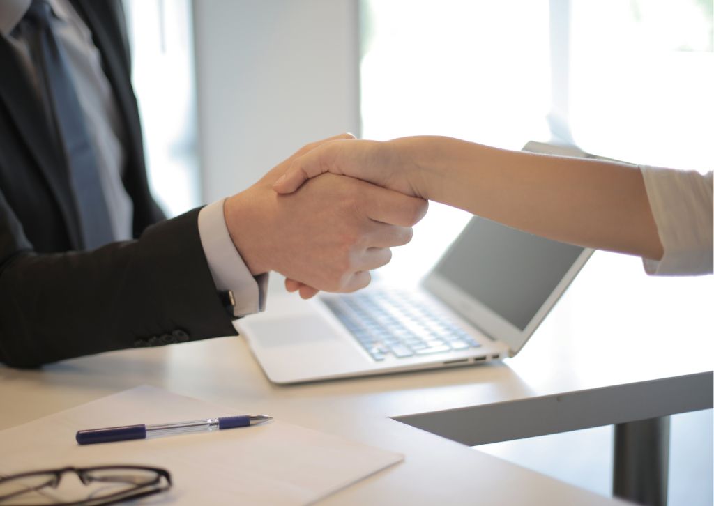 imprenditore e consulente si stringono la mano in ufficio